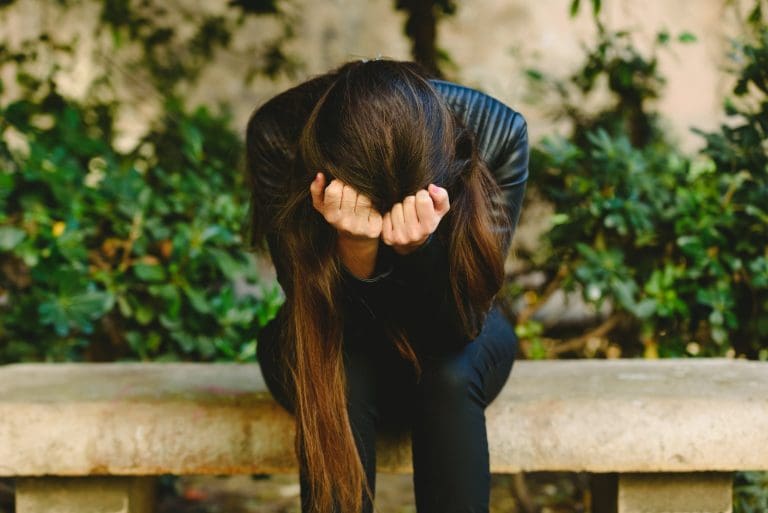 Depressed young woman holding head in hands feeling hurt upset, sad having psychological trauma.